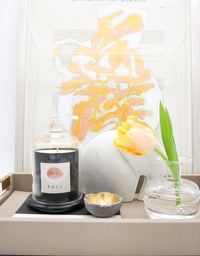 Clear bud vase with flower on decorative tray