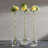 Three clear stem vases with flowers