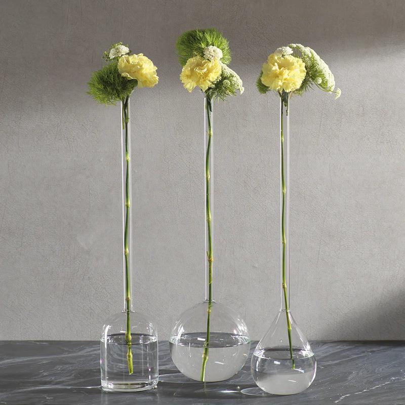 Three clear stem vases with flowers