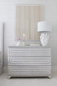Matte white sculptural lamp on dresser