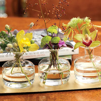 Flowers in set of three clear bud vases with wide bottom