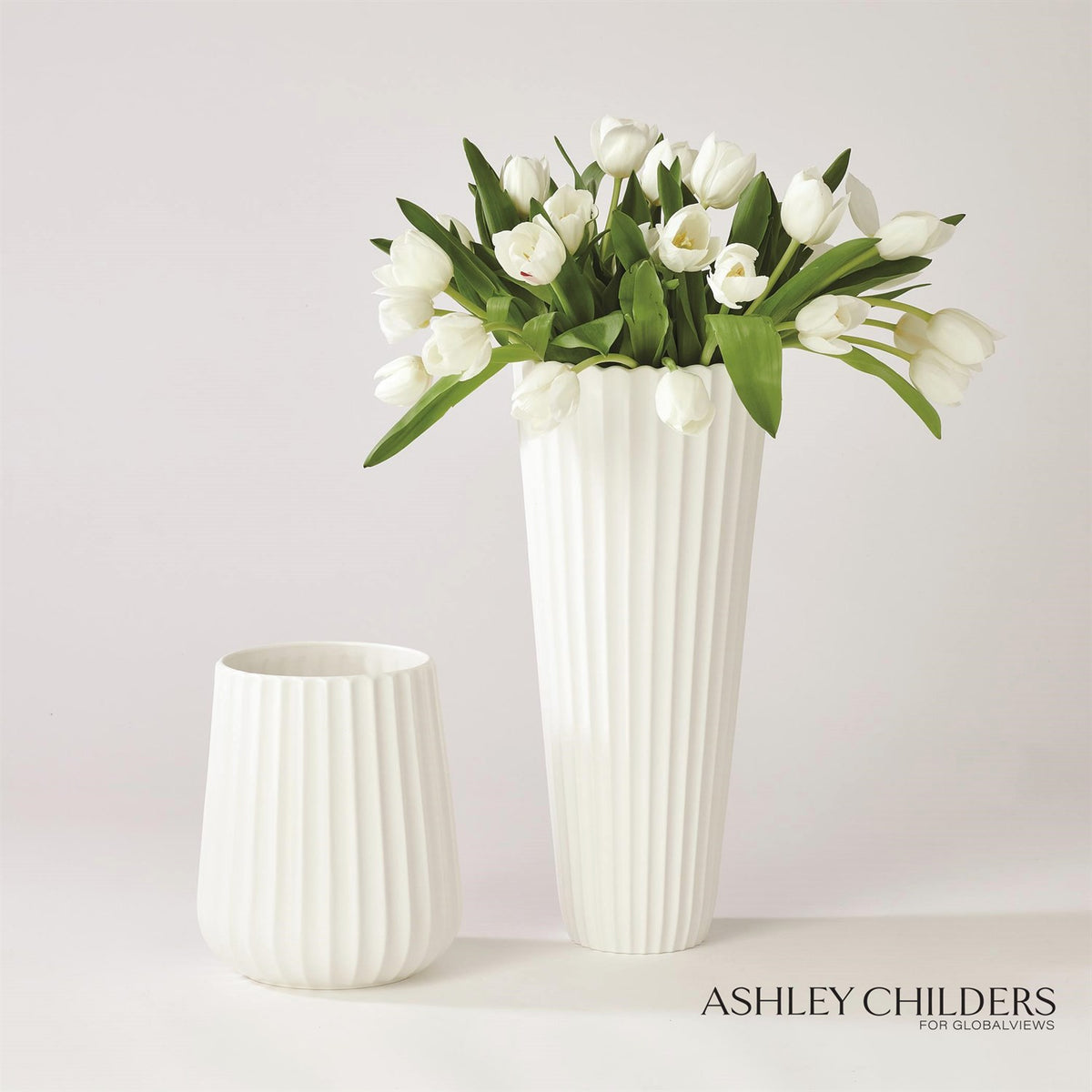 Small and large fluted white vases with tulips